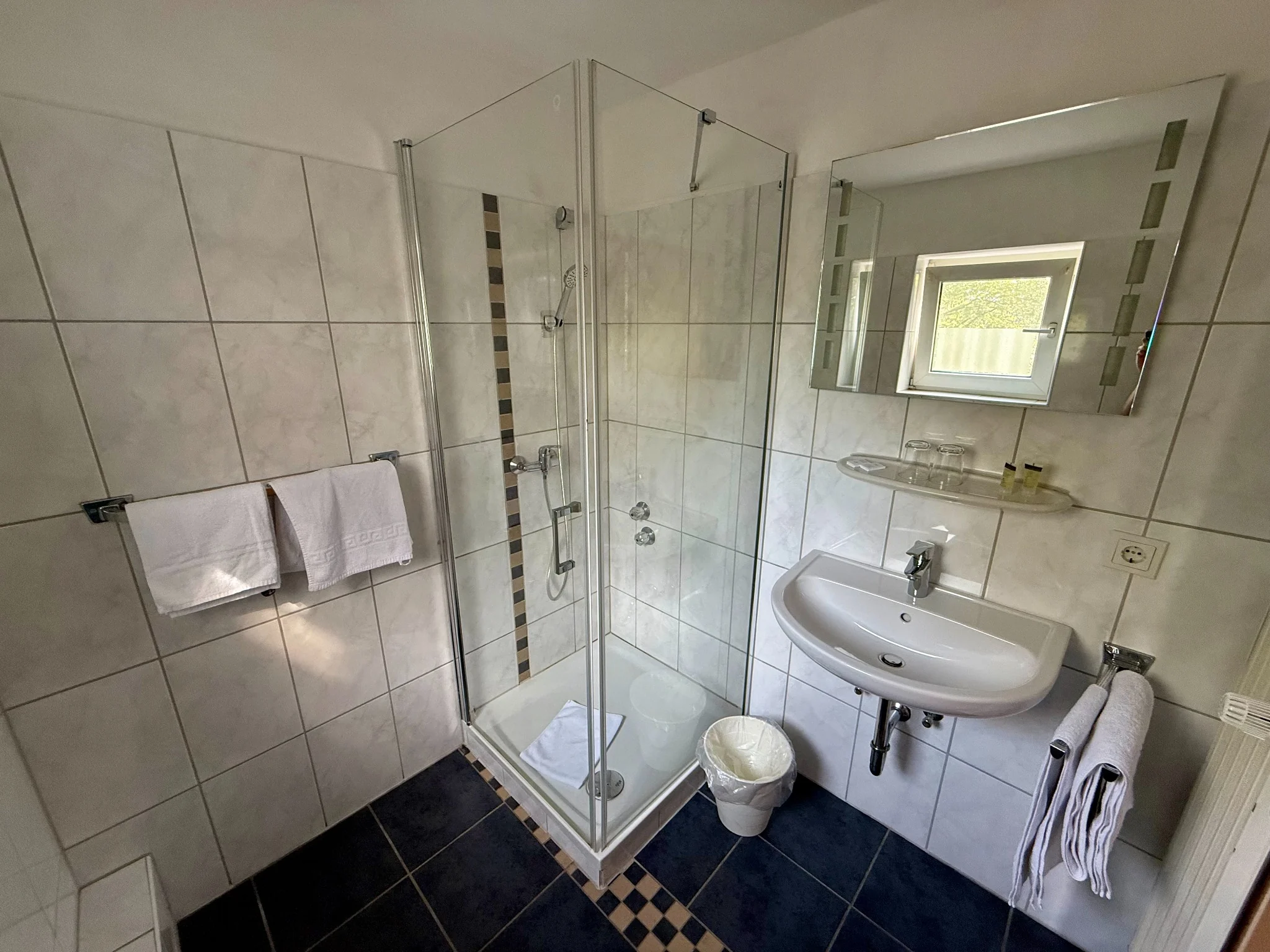 Dusche und Waschbecken im Badezimmer des Doppelzimmers