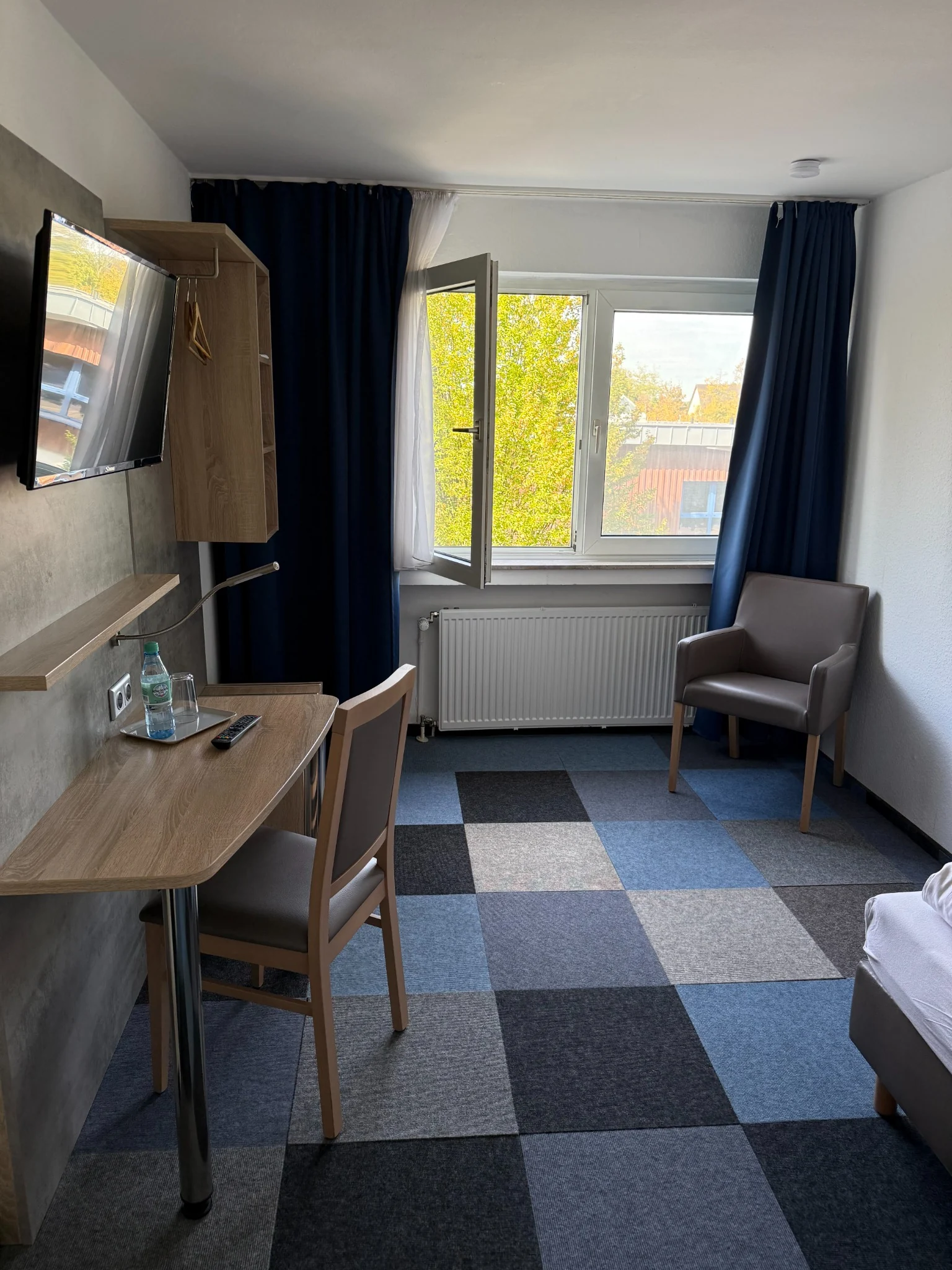 Einzelzimmer mit Sitzbereich und Schreibtisch