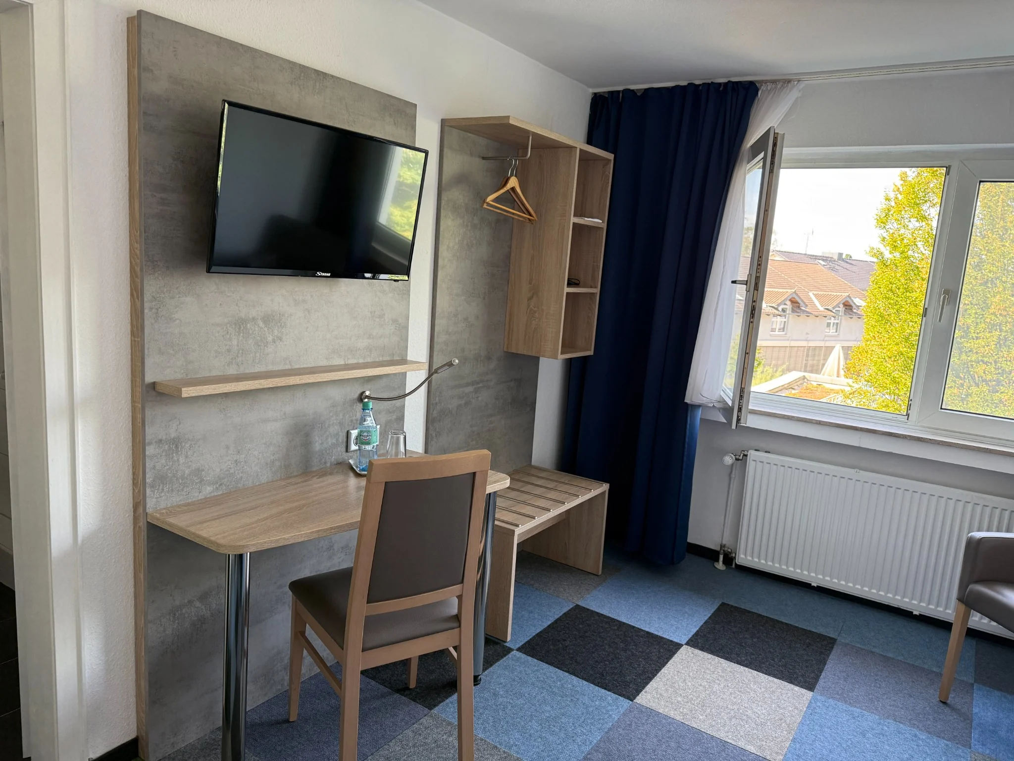 Schreibtisch und Fernseher im Einzelzimmer