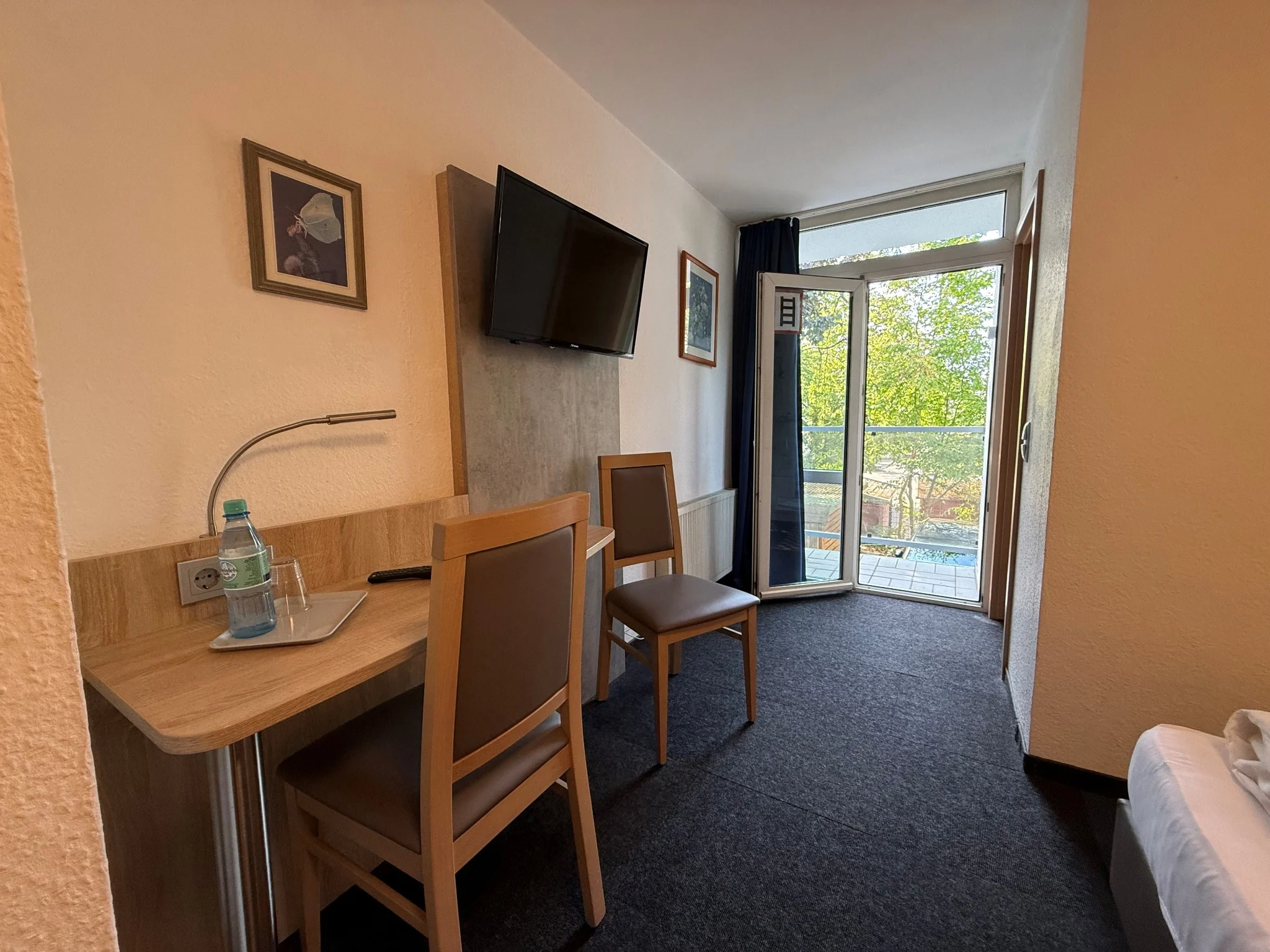 Zweibettzimmer mit Schreibtischen und Balkonzugang